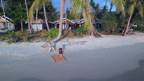 yoga girl stand on one leg fitness exercise palmtree at sunset seacret beach