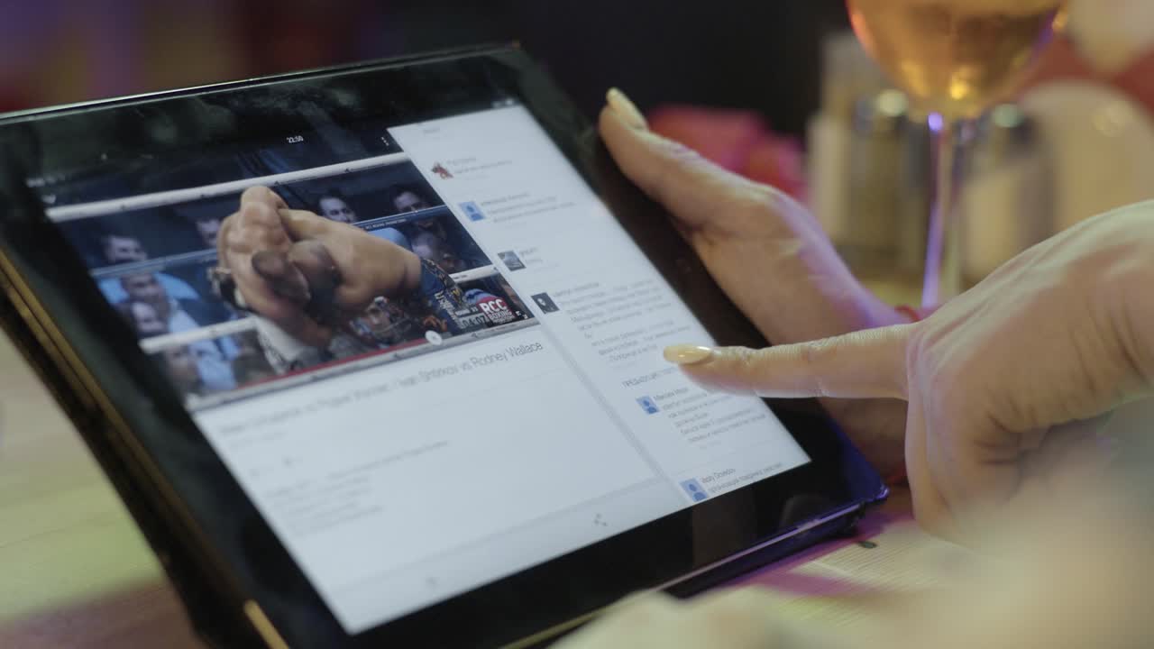 mujer viendo video en una tableta en un restaurante