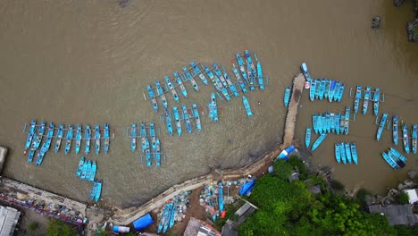 aerial top down shot of several blue fisherman boats anchored at harbor of yogyakarta, indonesia