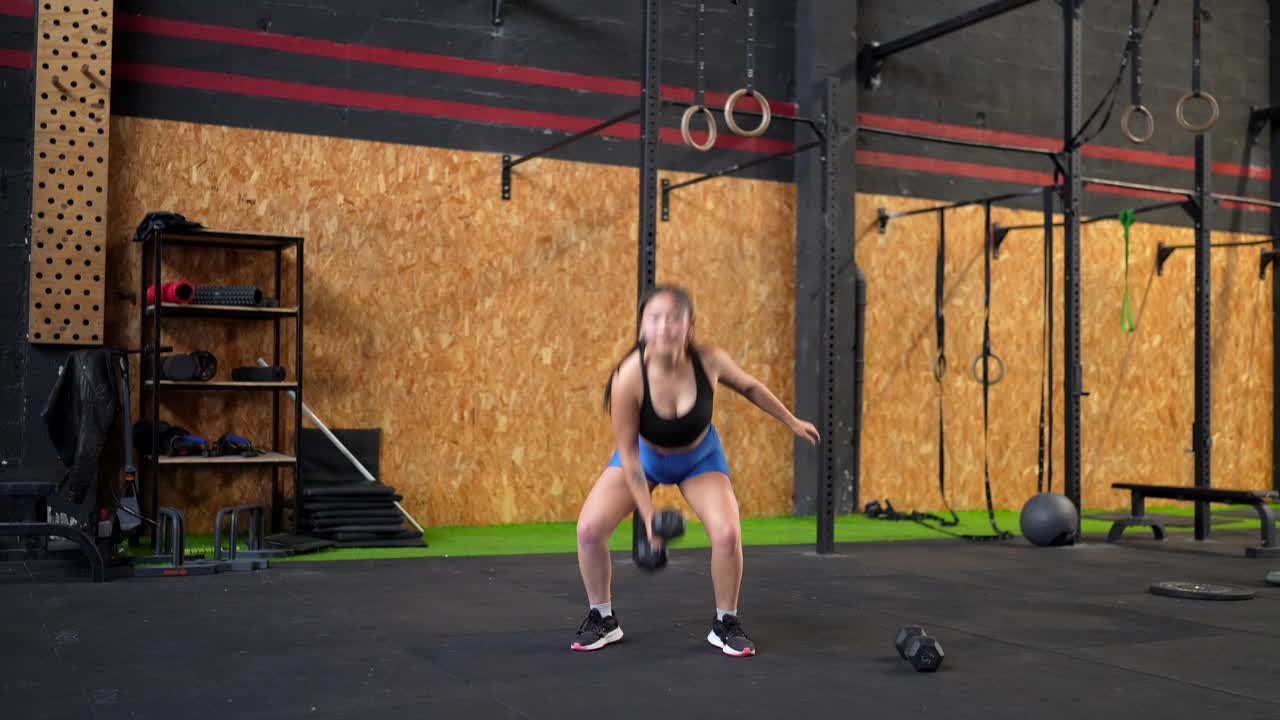 Woman exercising with dumbbell in gym