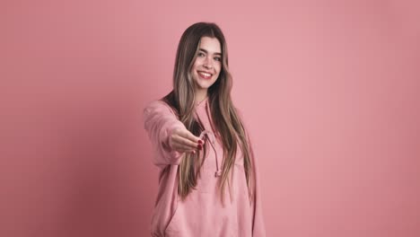 happy woman showing dental clear aligner in pink studio