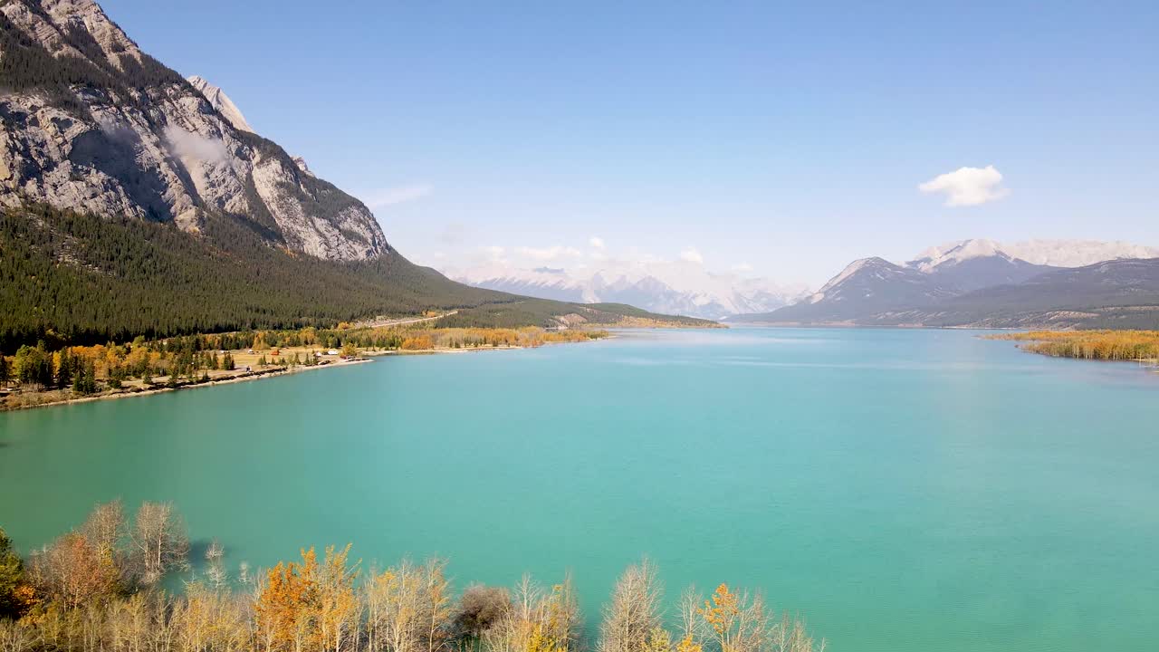 나무와 호수 위를 가로질러 날아가는 드론