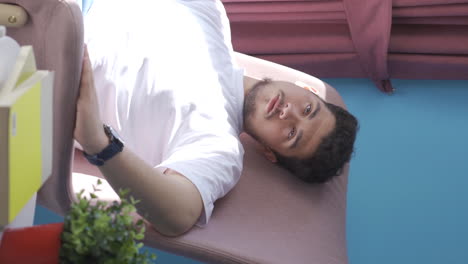 Vertical video of Unwell man watches out the window to relax.