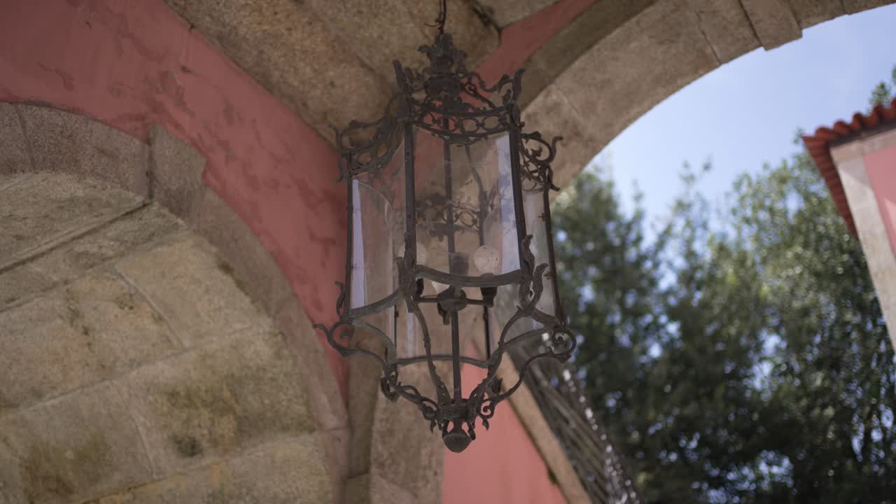 Ornate Antique Lantern Hanging Under a Stone Archway