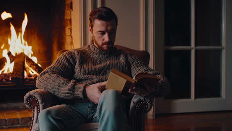 man reading by the fireplace