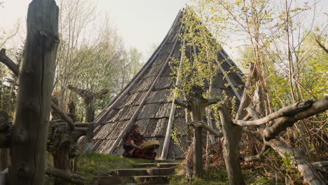 Musicain-in-shaman-costume-plays-ritual-drum-near-ail