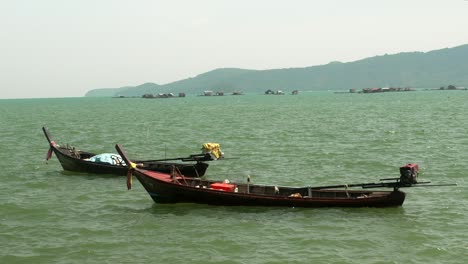 fisherman long boat at phuket thailand dock background mountain