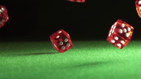 red dice falling on green felt