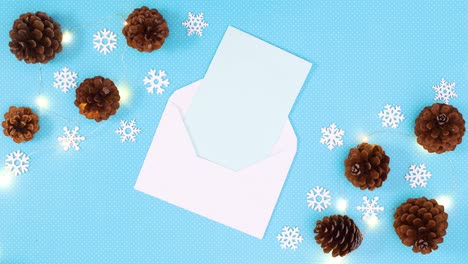 paper in envelope for christmas wishes on blue theme with pinecones and snowflakes. stop motion