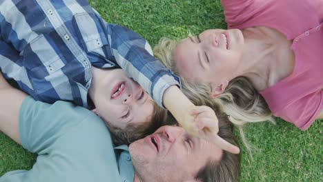 Happy-caucasian-couple-with-son-playing-and-lying-in-garden