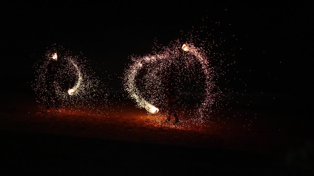 눈부신 불 공연은 해변 관객들을 매료시니다.