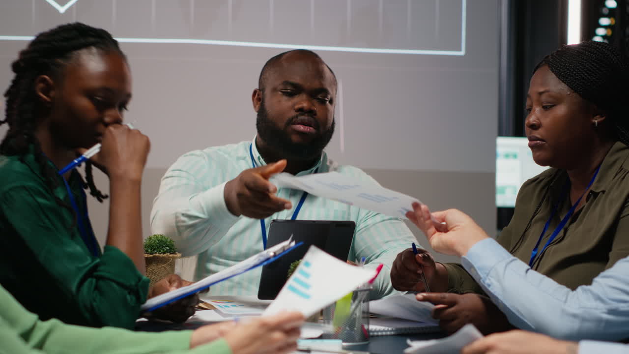 Diverse employees discuss project details and forecast information