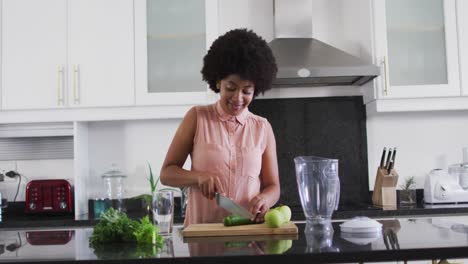 African-american-woman-chopping-vegetables-in-the-kitchen-at-home