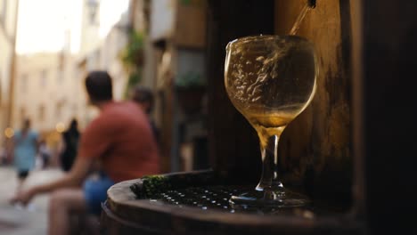 fuente de agua potable con copa de vino en florencia, italia