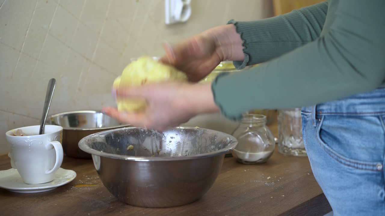La mujer está amasando la masa en la cocina.