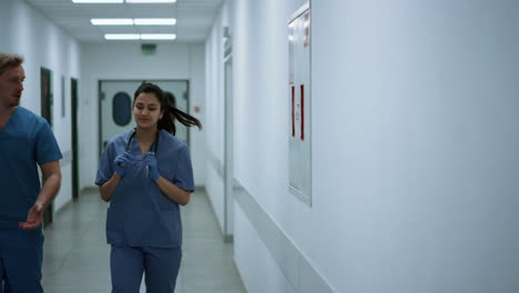 Médicos-Caminando-Por-El-Pasillo-Discutiendo-El-Diagnóstico.-Los-Médicos-Se-Apresuran-A-La-Operación.