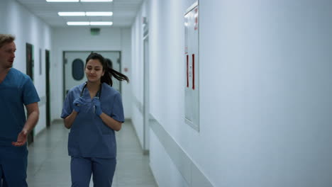los médicos caminan por el pasillo discutiendo el diagnóstico, los médicos se apresuran a operar.