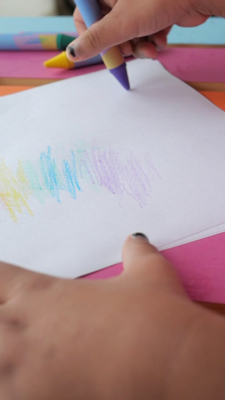 Close-up of Child's Hand Coloring with Crayons on Paper