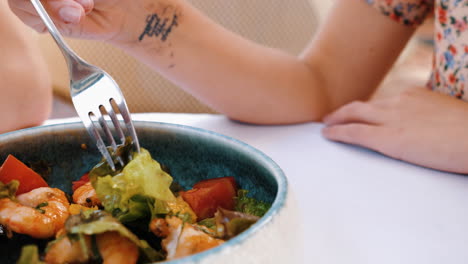 person eating shrimp salad at a restaurant