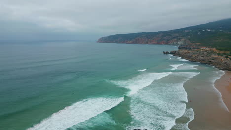 drone picturesque waves washing cliff-lined coastline. sandy beach hug ocean