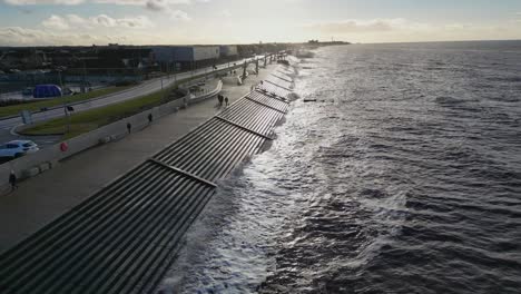 slow motion waves on sea defences in winter at cleveleys with drone rise up