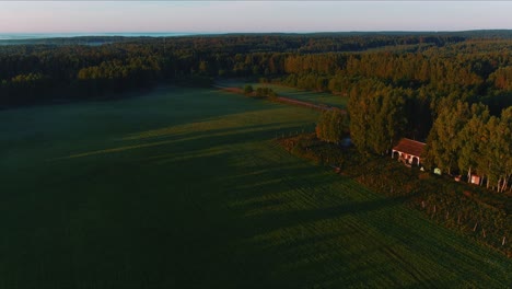 Toma-Aérea-De-Un-Paisaje-Rural-Con-Casa,-Campos-Verdes-Y-árboles