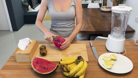 una mujer preparando un batido de frutas.