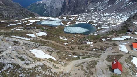 Impresionante-Vista-Aérea-De-Drones-Del-Paisaje-Del-Lago-Tre-Cime-Di-Lavaredo,-De-Lado