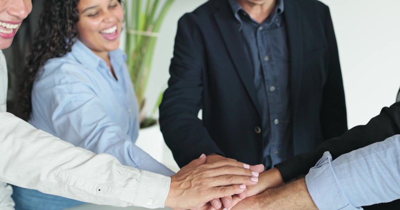 Equipo de negocios diverso apilando las manos en la oficina