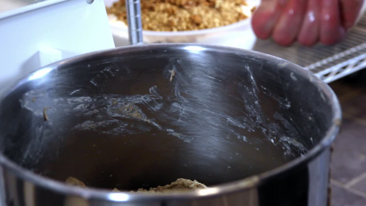 big lump of dough taken out the mixer by baker, close