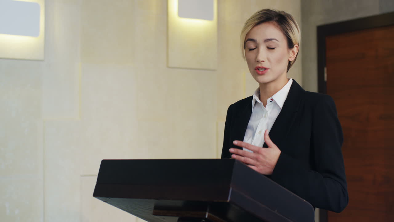 연단에 정장을 입고 많은 사람들 앞에서 회의에서 연설하는 백인 사업가의 클로즈업 보기