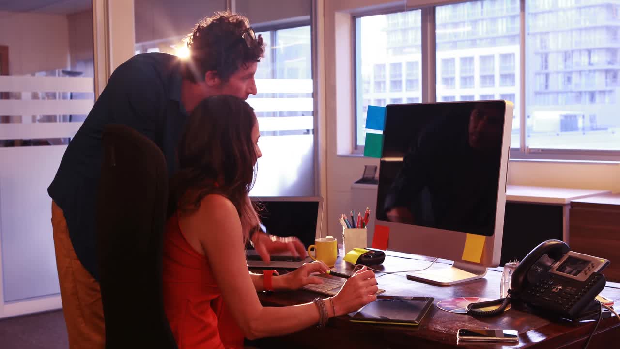 남성과 여성 그래픽 디자이너가 그래픽 태블릿을 사용하면서 상호 작용합니다.