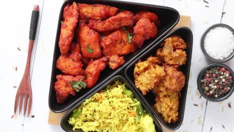 pollo frito indio picante servido con verduras al curry, arroz, cebolla, pan naan bhajia