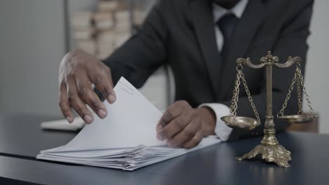 african american lawyer working on a lawsuit or complaint and going through paperwork, faceless