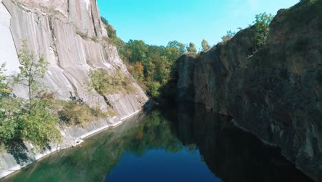 Vuelo-Aéreo-De-Drones-Sobre-Un-Lago-De-Montaña,-Un-Lago-Escondido-En-Praga,-Prokopské-Jezírko,-Colorgraded