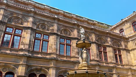vienna, austria - june 9, 2025: tourists at historic fountain in wien. visitors admire the ornate fountain beside a historic building in wien, capturing the beauty of european architecture