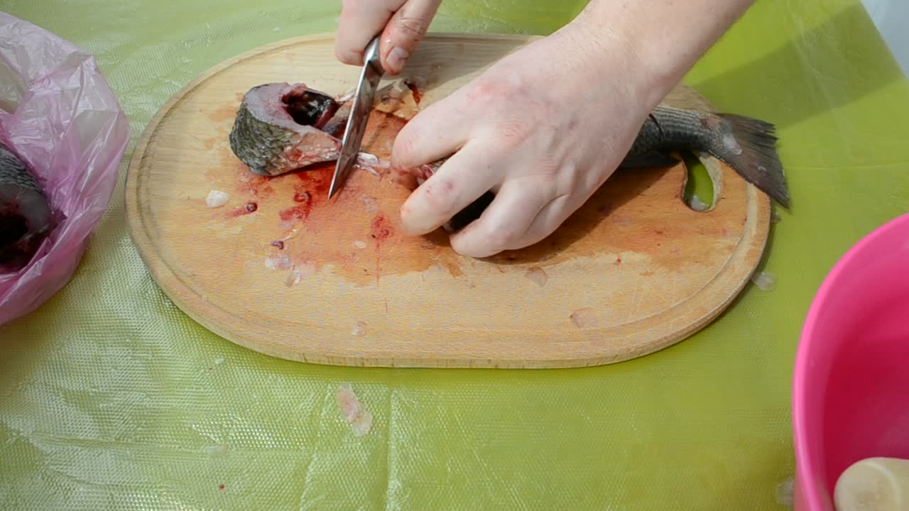 The cook cleans fish. Fish on a kitchen board