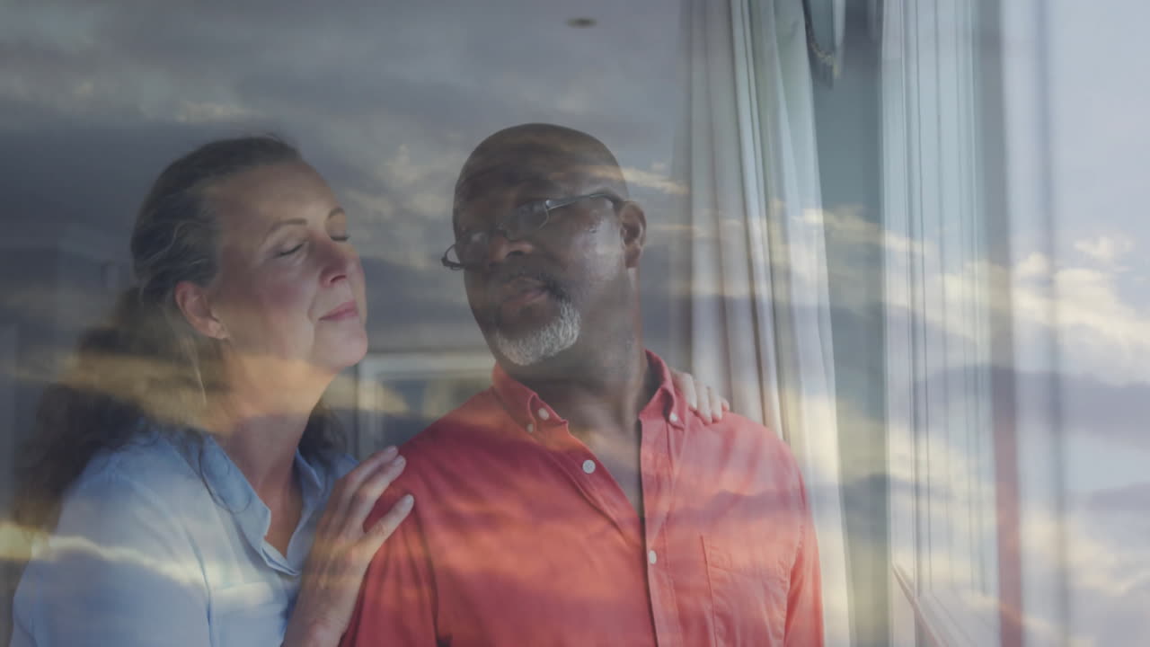 Looking out window, middle-aged couple with sunset sky reflection animation