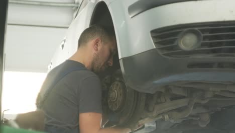 car mechanic repairing a car undercarriage