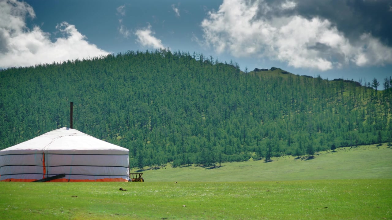 Traditionell mongolisk jurta i en grön bergsdal