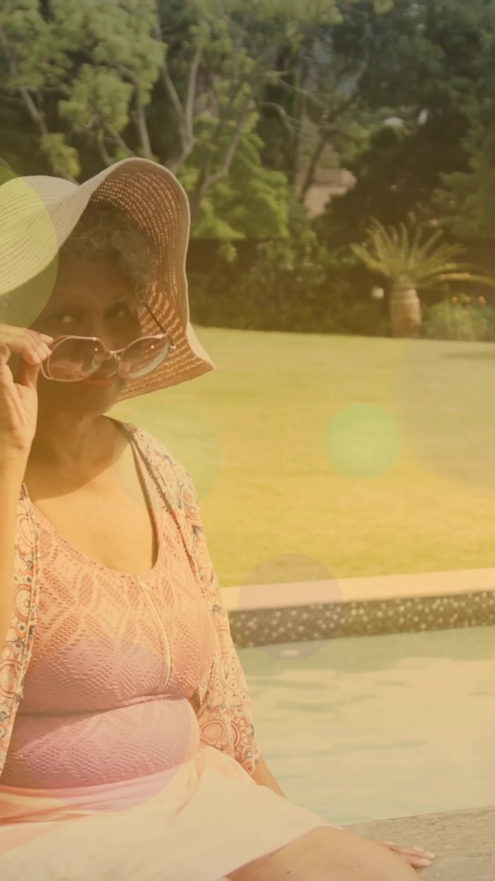Wearing sunhat and sunglasses, woman sitting by pool, colorful light animation