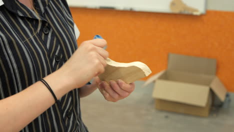 estudiante lijando un trozo de madera con papel de lija, de cerca