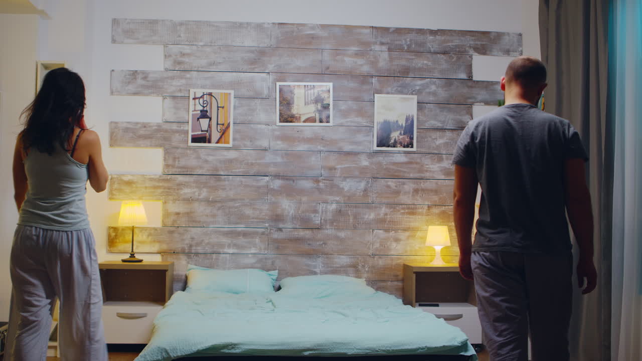 결혼 한 백인 부부 가 침대 에 다시 쓰러지고 있다