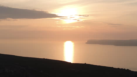 aerial telephoto shot of the sunset reflecting from the mediterranean sea in malta