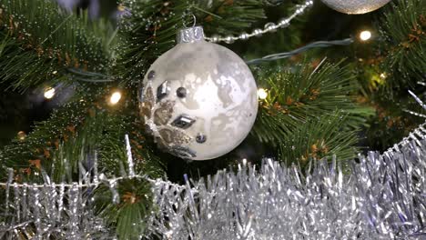 Christmas-tree-decorated-with-lights,-silver-garlands-and-balls