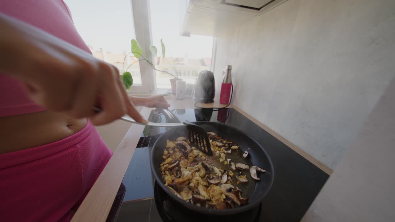 Woman cooking food in a frying pan
