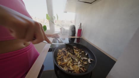 woman cooking food in a frying pan