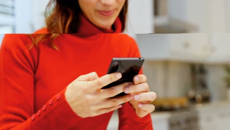 Woman-using-mobile-phone-in-kitchen-4k