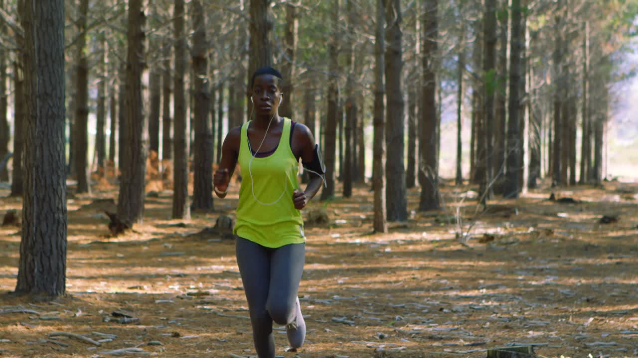 Female jogger running in the forest 4k