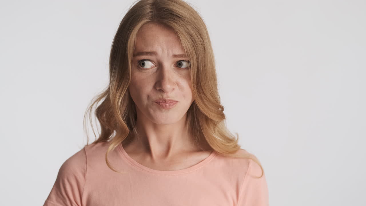 una mujer caucásica masticando en la cámara.